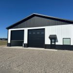 white and black shop with two doors man door and a window
